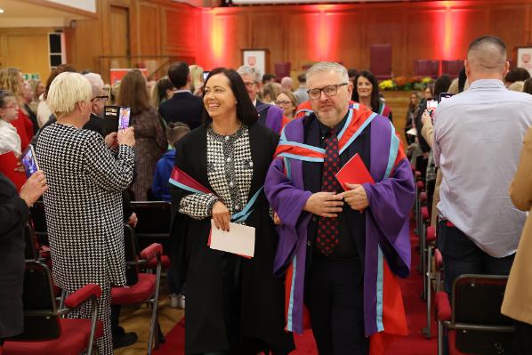 A smiling member of the academic procession